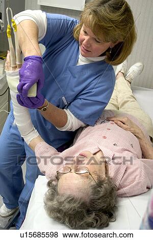Clinic nurse recasting broken wrist of patient View Large Photo Image Stock Photo - Clinic nurse recasting broken wrist of patient. Fotosearch
