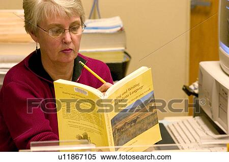 Helpful librarian finding a reference in the Lakota Language textbook View Large Photo Image Stock Photography - Helpful librarian finding a reference in the Lakota Language textbook. Fotosearch