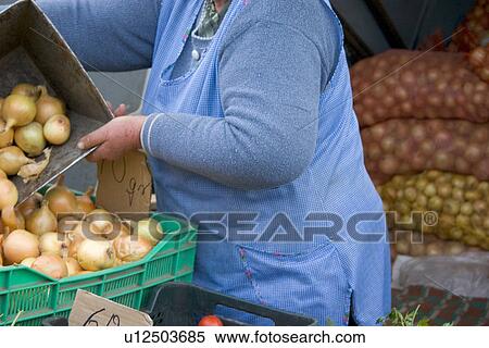 Stock Photography - Merchant selling fresh onions at the Balucki Rynek market. Fotosearch