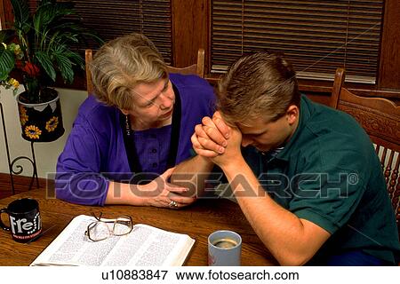 Stock Photo - Aunt and nephew working on personal problem with Bible. Fotosearch