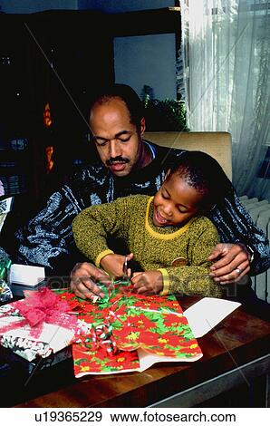 Father helping son wrap Christmas gifts View Large Photo Image Stock Photo - Father helping son wrap Christmas gifts. Fotosearch