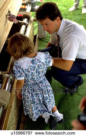 Stock Photo - Father with daughter at the burial of grandmother. Fotosearch
