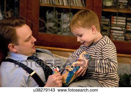 Son enthusiastically showing dad his wrapped birthday gift View Large Photo Image Stock Image - Son enthusiastically showing dad his wrapped birthday gift. Fotosearch