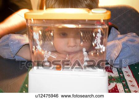 Stock Photograph - Boy looking into a water game. Fotosearch