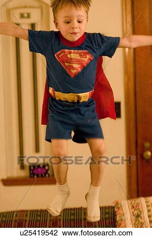 Stock Image - Superman taking a flying leap off couch while his mother was in the other room. Fotosearch