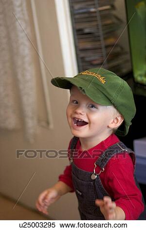 Toddler laughing and wearing baseball hat View Large Photo Image Stock Photography - Toddler laughing and wearing baseball hat. Fotosearch