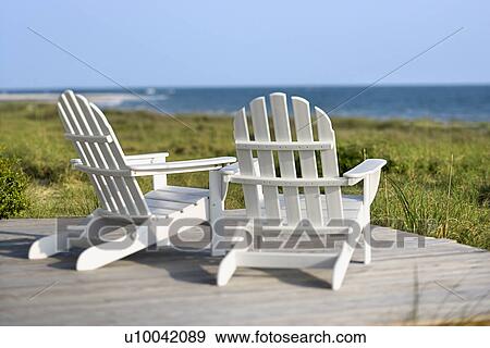Adirondack chairs on deck looking towards beach on Bald Head Island, North Carolina. View Large Photo Image Stock Photo - Adirondack chairs on deck looking towards beach on Bald Head Island, North Carolina.. Fotosearch