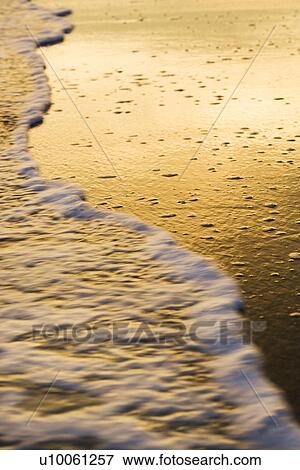 Waves lapping at beach at sunset. View Large Photo Image Stock Photo - Waves lapping at beach at sunset.. Fotosearch