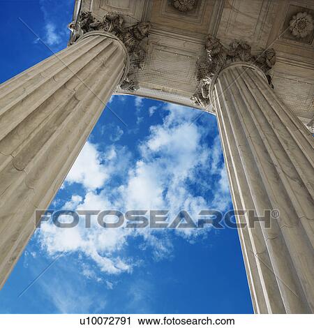 Stock Image - Low angle view looking up at blue sky with clouds and columns of Supreme Court building in Washington D. C.. Fotosearch