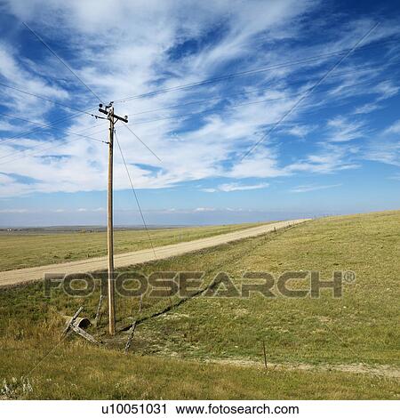 Stock Image - Power lines alongside dirt road in rural South Dakota.. Fotosearch