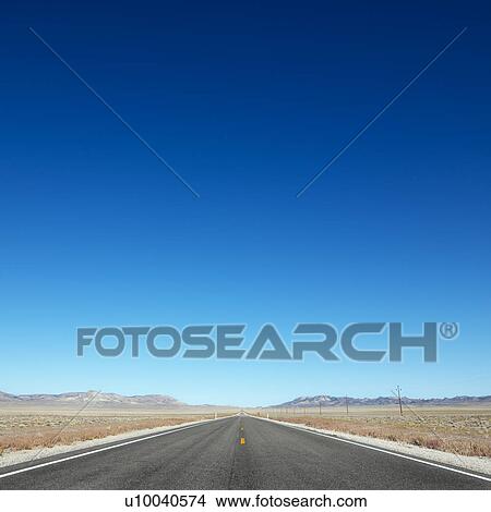 Strip of highway stretching towards horizon under clear blue sky. View Large Photo Image Picture - Strip of highway stretching towards horizon under clear blue sky.. Fotosearch