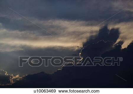 Stock Photo - Sun peeking through clouds.. Fotosearch