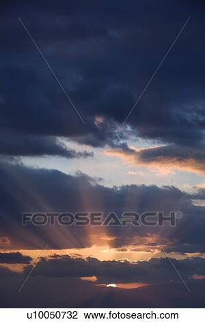 Sunbeams coming through clouds at sunrise over Maui, Hawaii, USA. View Large Photo Image Stock Image - Sunbeams coming through clouds at sunrise over Maui, Hawaii, USA.. Fotosearch