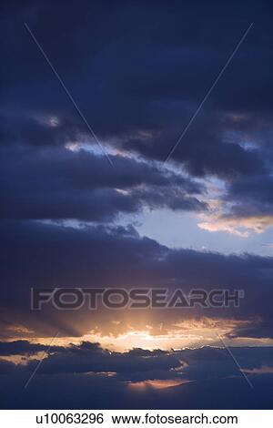 Sunbeams coming through clouds at sunrise over Maui, Hawaii, USA. View Large Photo Image Stock Photograph - Sunbeams coming through clouds at sunrise over Maui, Hawaii, USA.. Fotosearch