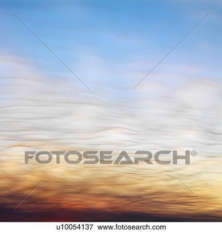 Wispy clouds in sunset colored sky. View Large Photo Image Stock Photo - Wispy clouds in sunset colored sky.. Fotosearch