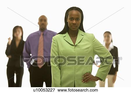 African-American businesswoman with hand on hip with others in background. View Large Photo Image Stock Photo - African-American businesswoman with hand on hip with others in background.. Fotosearch