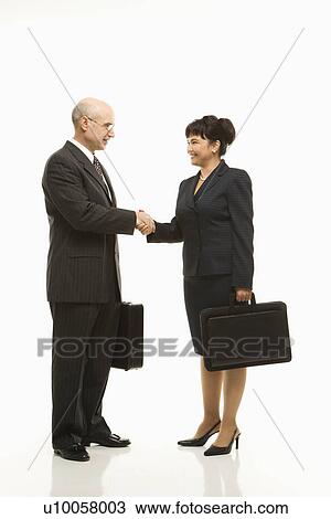 Caucasian middle-aged businessman and Filipino businesswoman standing looking at eachother shaking hands against white background. View Large Photo Image Stock Image - Caucasian middle-aged businessman and Filipino businesswoman standing looking at eachother shaking hands against white background.. Fotosearch