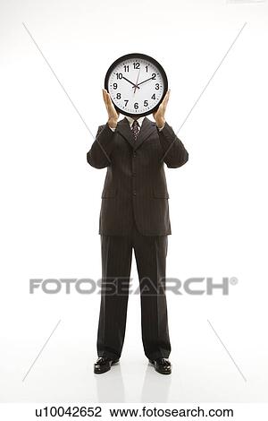 Caucasian middle-aged businessman holding clocks in front of their heads standing against white background. View Large Photo Image Stock Image - Caucasian middle-aged businessman holding clocks in front of their heads standing against white background.. Fotosearch