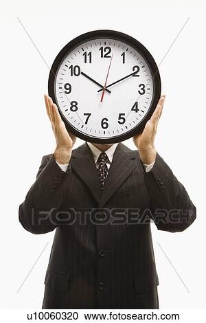 Caucasian middle-aged businessman holding clocks in front of their heads standing against white background. View Large Photo Image Stock Image - Caucasian middle-aged businessman holding clocks in front of their heads standing against white background.. Fotosearch