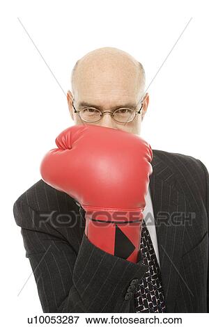 Stock Photo - Caucasian middle-aged man holding up hand with red boxing glove up to face.. Fotosearch