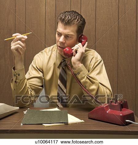 Caucasion mid-adult retro businessman sitting at desk talking on telephone. View Large Photo Image Stock Photo - Caucasion mid-adult retro businessman sitting at desk talking on telephone.. Fotosearch