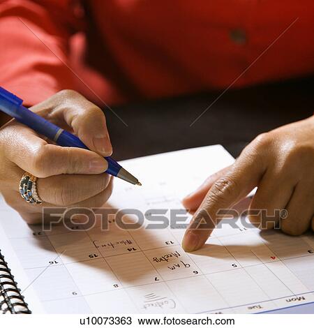 Close-up of businesswoman writing in appointment calendar. View Large Photo Image Stock Image - Close-up of businesswoman writing in appointment calendar.. Fotosearch