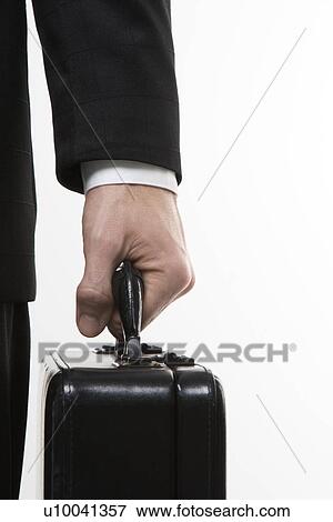 Stock Photo - Close-up of Caucasian mid-adult man's hand holding briefcase.. Fotosearch