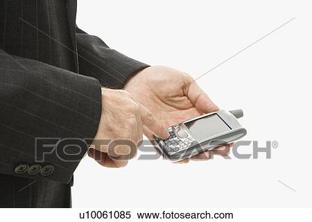 Stock Photography - Close-up of Caucasian middle-aged businessman using handheld PDA.. Fotosearch