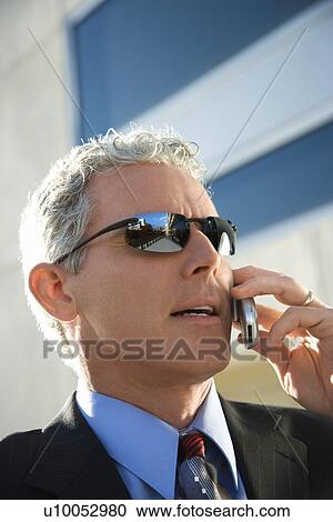 Close up side view of prime adult Caucasian man in suit talking on cellphone in urban setting. View Large Photo Image Stock Image - Close up side view of prime adult Caucasian man in suit talking on cellphone in urban setting.. Fotosearch