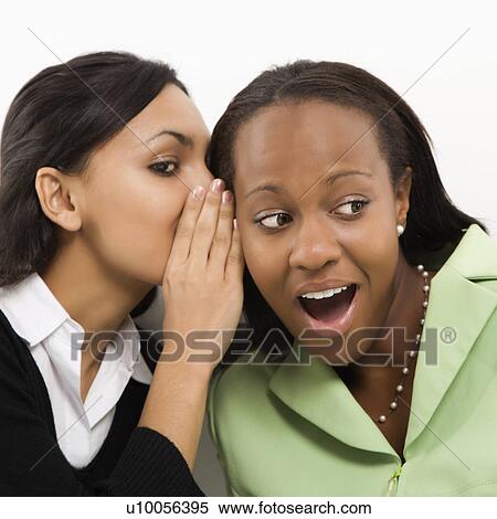 Indian young adult woman whispering in ear of mid-adult African-American woman. View Large Photo Image Stock Photography - Indian young adult woman whispering in ear of mid-adult African-American woman.. Fotosearch
