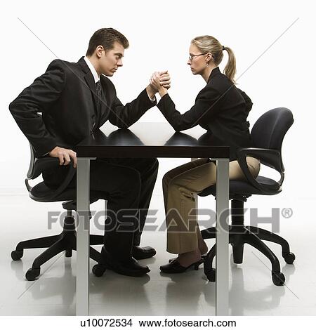 Side view of Caucasian mid-adult businessman and businesswoman arm wrestling on table. View Large Photo Image Picture - Side view of Caucasian mid-adult businessman and businesswoman arm wrestling on table.. Fotosearch