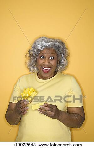 African American female mature adult opening gift box looking surprised and happy. View Large Photo Image Stock Photo - African American female mature adult opening gift box looking surprised and happy.. Fotosearch