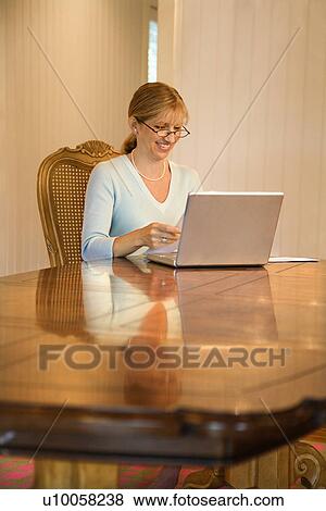 Caucasian mid-adult woman using laptop computer. View Large Photo Image Stock Photo - Caucasian mid-adult woman using laptop computer.. Fotosearch