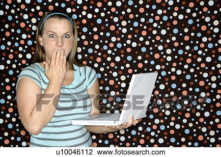 Young Caucasian woman holding laptop looking shocked. View Large Photo Image Stock Image - Young Caucasian woman holding laptop looking shocked.. Fotosearch