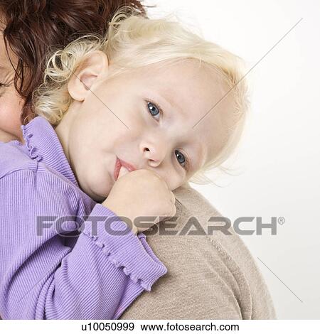 Caucasian female toddler sucking her thumb while her mother holds her. View Large Photo Image Stock Photo - Caucasian female toddler sucking her thumb while her mother holds her.. Fotosearch