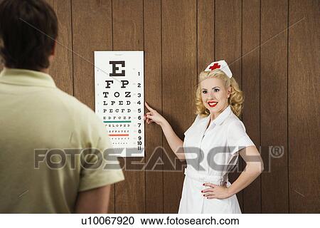 Caucasian mid-adult female nurse pointing out eye chart to mid-adult male patient. View Large Photo Image Stock Image - Caucasian mid-adult female nurse pointing out eye chart to mid-adult male patient.. Fotosearch
