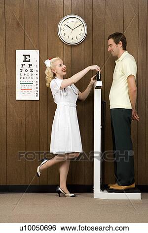 Caucasian mid-adult female nurse weighing man on scale. View Large Photo Image Stock Photograph - Caucasian mid-adult female nurse weighing man on scale.. Fotosearch