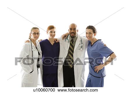 Stock Image - Half-length portrait of African-American man and Caucasian women medical healthcare workers in uniforms with arms around eachother standing against white background.. Fotosearch