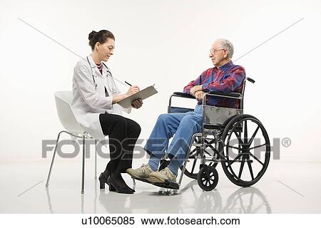 Stock Photography - Mid-adult Caucasian female doctor taking notes with an elderly Caucasian male in wheelchair to her side.. Fotosearch