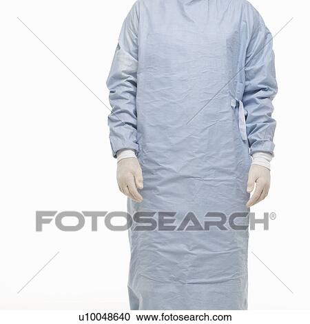 Stock Image - Mid-adult Caucasian male wearing scrubs and medical latex gloves.. Fotosearch