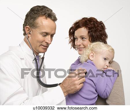 Stock Image - Middle-aged adult Caucasian male doctor holding stethoscope to female toddler's back with mother watching.. Fotosearch