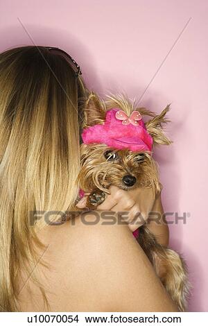 Picture - Caucasian young adult female holding Yorkshire Terrier dog.. Fotosearch