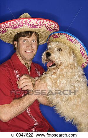 Fluffy brown dog and Caucasian male young adult wearing Mexican sombreros. View Large Photo Image Stock Image - Fluffy brown dog and Caucasian male young adult wearing Mexican sombreros.. Fotosearch