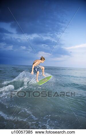 Caucasian male teen riding skimboard. View Large Photo Image Stock Photography - Caucasian male teen riding skimboard.. Fotosearch