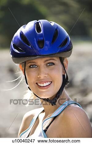 Stock Photo - Caucasian mid-adult woman wearing bicycle helmet looking at viewer smiling.. Fotosearch