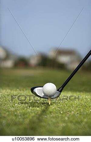 Stock Photograph - Image of golf ball on tee with golf club behind ball.. Fotosearch