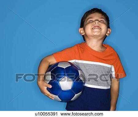 Stock Image - Male Hispanic boy holding soccer ball.. Fotosearch