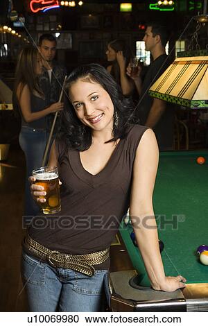 Portrait of young caucasian woman holding beer beside billiards table in pub. View Large Photo Image Stock Image - Portrait of young caucasian woman holding beer beside billiards table in pub.. Fotosearch