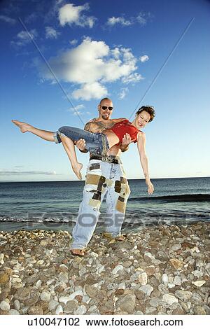 Prime adult Caucasian male carrying young adult Caucasian female. View Large Photo Image Stock Image - Prime adult Caucasian male carrying young adult Caucasian female.. Fotosearch