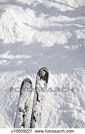 Stock Photo - Skis dangling on top of trail drop.. Fotosearch